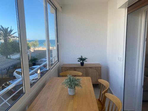 una sala da pranzo con un tavolo e una grande finestra di Miramar 14A a Roses