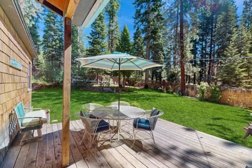 a patio with a table and chairs and an umbrella at Casual and Cute Cabin Near the Lake in Tahoe Vista