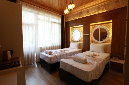 a bedroom with two beds with a mirror and a mirror at Bacchus Pension in Antalya