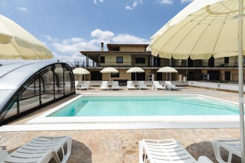 a swimming pool with chairs and a building at Villa Olivieri B&B Wellness House in Viterbo