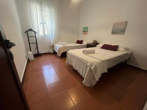 a room with two beds in a room with a window at PINO BEACH in Punta Umbría