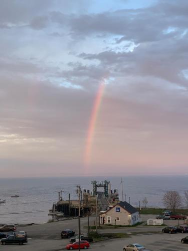 un arco iris en el cielo sobre el agua en Eco-friendly studio - ocean views, close to beach, en Lincolnville