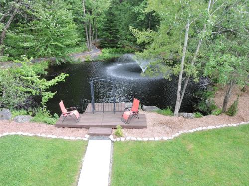 two chairs sitting on a deck near a body of water at Gite Passion et Tendresse B&B in Shefford
