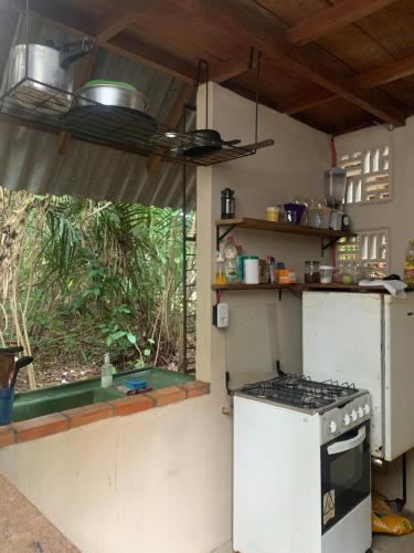 a kitchen with a stove and a window at Estudio Embira - Lago Verde in Santarém