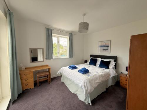 une chambre avec un lit avec des serviettes bleues dessus dans l'établissement Pass the Keys Gorgeous 3 BR Cottage with Outstanding Sea Views, à Isle of Whithorn
