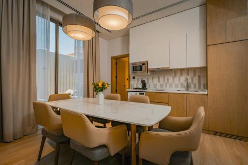 a kitchen and dining room with a table and chairs at First Grand Hotel in Dammam