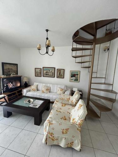 a living room with a couch and a spiral staircase at Villa Georgia Poseidi in Kalandra