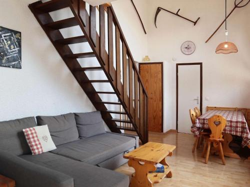 - un salon avec un canapé bleu et un escalier dans l'établissement Triplex familial Les Orres, 12 pers, piste directe - FR-1-322-591, aux Orres