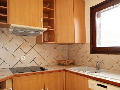 une cuisine avec des armoires en bois, un évier et une fenêtre dans l'établissement Triplex familial Les Orres, 12 pers, piste directe - FR-1-322-591, aux Orres