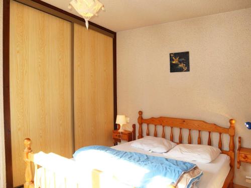 une chambre avec deux lits et un lustre dans l'établissement Triplex familial Les Orres, 12 pers, piste directe - FR-1-322-591, aux Orres