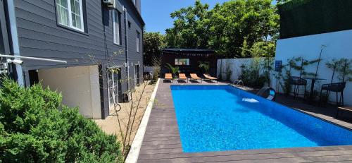 a swimming pool in a yard next to a house at villa gardens in K'obulet'i