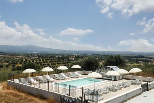 a resort with a swimming pool with chairs and umbrellas at Villa Olivieri B&B Wellness House in Viterbo