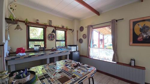 a kitchen with a counter and a table in a room at House of Art in Haenertsburg