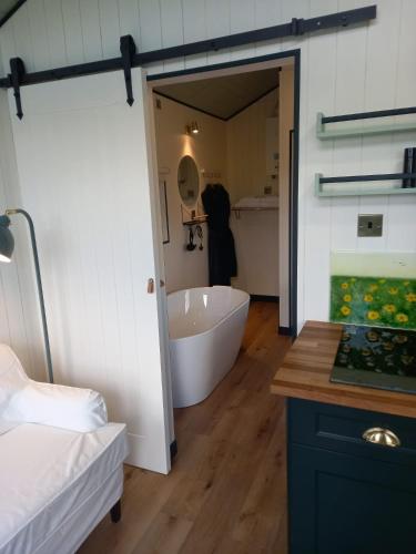 a bathroom with a bath tub and a sink at Wild Meadow Huts in Doolin