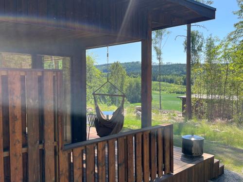 a hammock hanging on a porch of a cabin at Sukha Nordic Retreats in Arvika