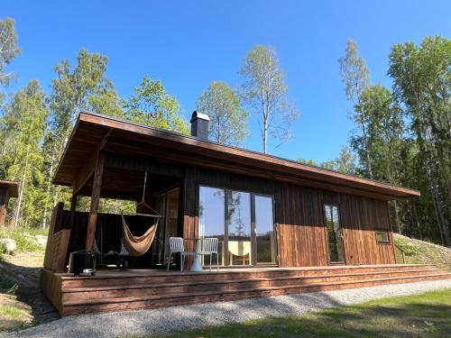 a cabin in the woods with a hammock in it at Sukha Nordic Retreats in Arvika