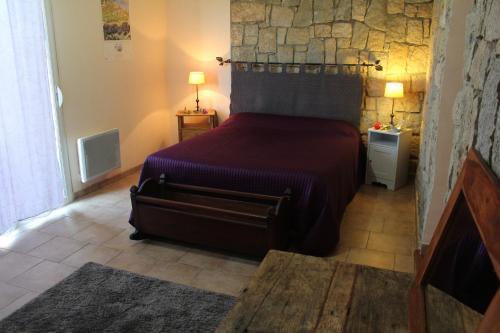 une chambre avec un lit et un mur en pierre dans l'établissement Maquis et plage, à Sollacaro