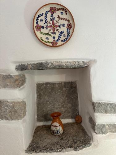 a clock on a wall above a fireplace with a vase at Katsi Traditional & Medieval House in Mesta