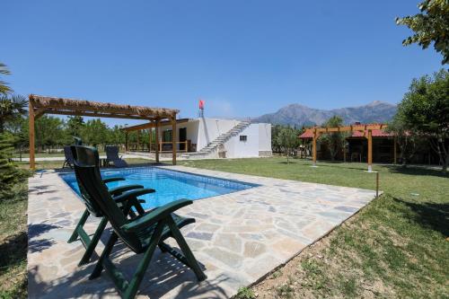 a pair of lawn chairs sitting next to a swimming pool at Guest House MICAJ in Himare