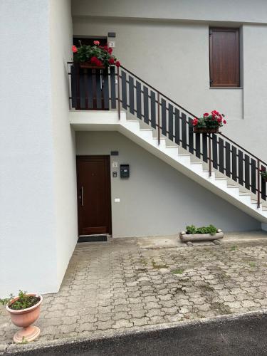 a building with stairs and flowers on it at Dimaro-Folgarida Apartment in Monclassico