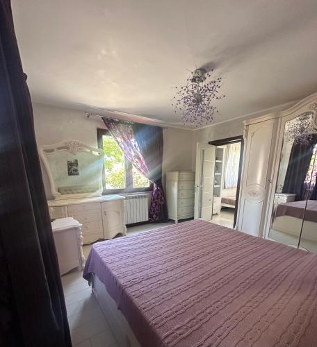 a bedroom with a bed with a purple bedspread at Casa Adi Sucevița in Voivodeasa