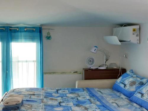 a bedroom with a blue bed and a window at Casa Blu with Sea View - Borgo Stays in Sperlonga