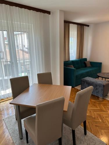 a living room with a table and chairs and a couch at Una La Unica in Bihać