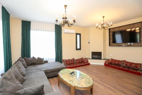 a living room with a couch and a tv at Guest House MICAJ in Himare