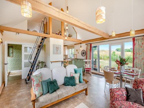 a living room with a couch and a ladder at Blackberry Barn in Maidstone