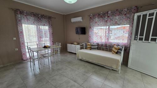 a bedroom with a bed and a table and windows at Vasilikis Place in Elafonisos