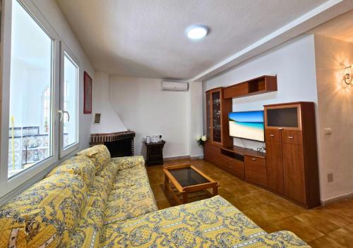 a living room with a couch and a large window at Bungalow Oaxaca Playa de La Mata in Torrevieja