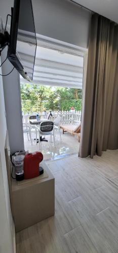 a living room with a view of a patio at Suncoast Rooms Saranda near Port & Beach in Sarandë