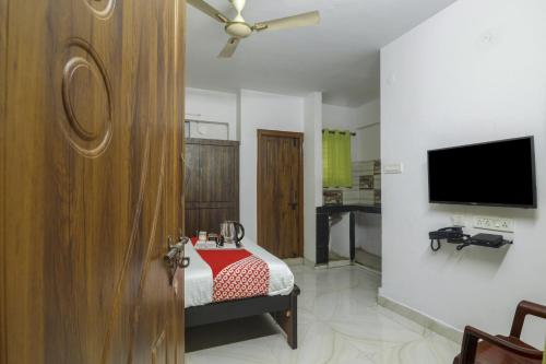 a bedroom with a bed and a flat screen tv at Hotel O RR in Hyderabad