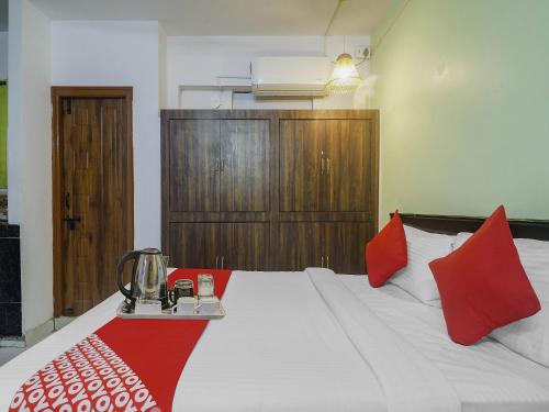 a bedroom with a large bed with red pillows at Hotel O RR in Hyderabad