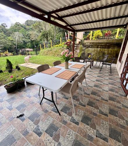 a patio with a table and chairs on a patio at Casa Bella Campestre in Guayabal de Síquima