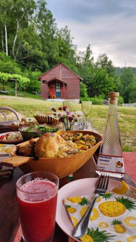 a table with a bowl of food and a bottle of wine at Kolibe Ćorić in Mojkovac