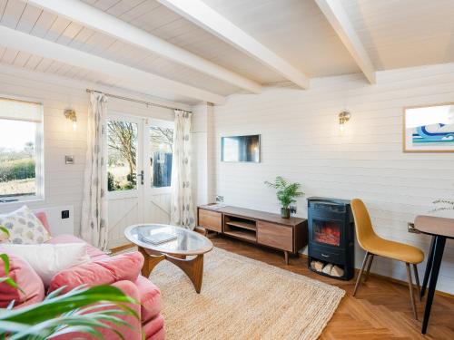 a living room with a couch and a fireplace at The Cosy Cabin in Clapton in Gordano