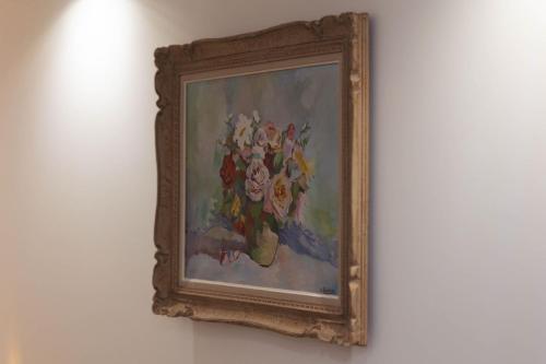 une peinture de fleurs dans un vase sur un mur dans l'établissement Grande maison des Compagnons, à Val de Reuil