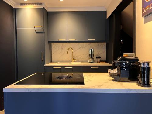 a kitchen with black cabinets and a counter top at Garden Street - Antiquity Blue in Lommel