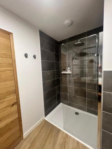 bagno con doccia e piastrelle nere di Appartements Prestiges I Draps&ménage inclus I parking privé a Saint-Lary-Soulan