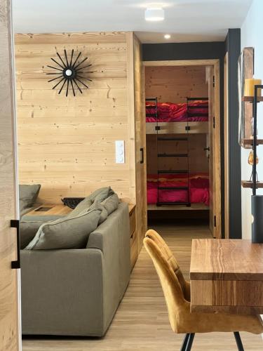 un soggiorno con divano e una camera da letto con letti a castello di Appartements Prestiges I Draps&ménage inclus I parking privé a Saint-Lary-Soulan