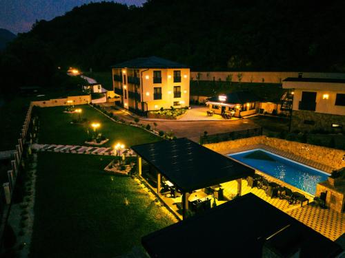a view of a building with a swimming pool at night at Hotel Alibabin Raj in Konjic