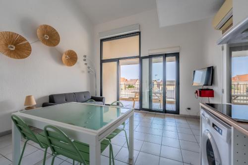 une cuisine et un salon avec une table et des chaises dans l'établissement Duplex situé a palavas les flots à 1 minute de la mer, à Palavas-les-Flots