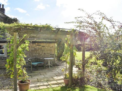 a garden with a pergola and a table at Winebeck Farm Studio in Addingham