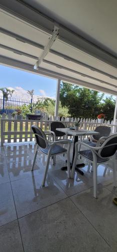 a table and chairs sitting under an umbrella at Suncoast Rooms Saranda near Port & Beach in Sarandë