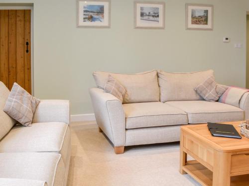 a living room with two couches and a coffee table at Addycombe Cottage in Rothbury