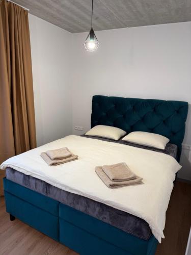 a bed with a blue headboard in a room at Diamond Houses in Námestovo