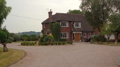 a large red brick house with a driveway at Private Room Near Stratford upon Avon in Snitterfield