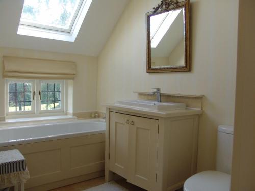 a bathroom with a tub and a sink and a mirror at Private Room Near Stratford upon Avon in Snitterfield