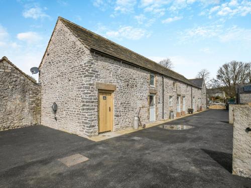a large brick building with a door on it at Middlecroft - Uk45062 in Tideswell
